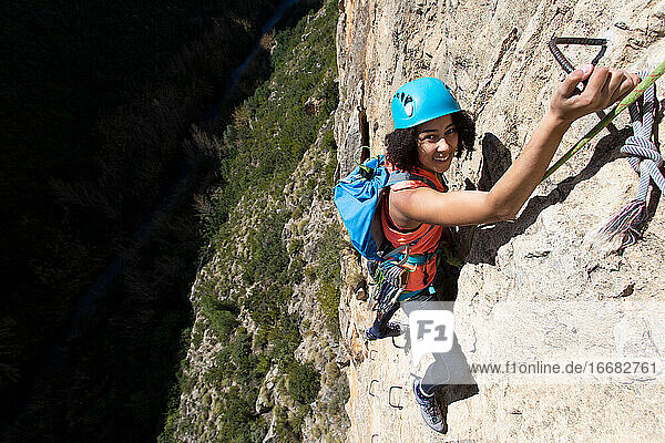 Junge Frau klettert durch einen Klettersteig in der Chulilla-Schlucht (Spanien)