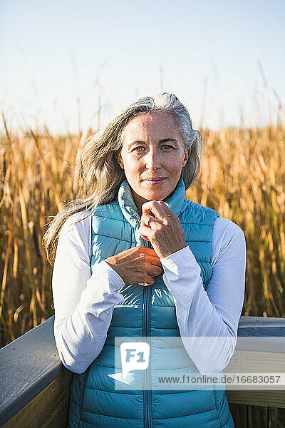 Grauhaarige Frau genießt einen Naturspaziergang im goldenen Sumpf