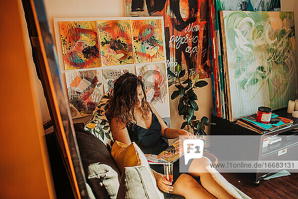 Künstlerin in ihrem Atelier  umgeben von Leinwand und Gemälden