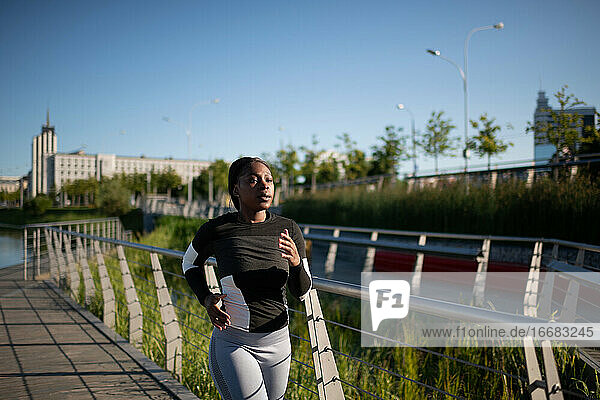 Afroamerikanische Sportlerin läuft auf einer Böschung