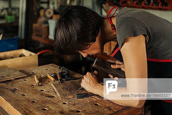 Frau bei der Arbeit an einer Werkbank  mit Handwerkzeugen