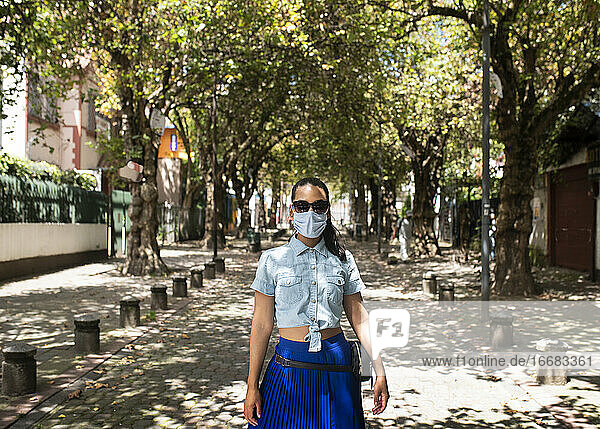 Adult woman walking in the street using mouth cover