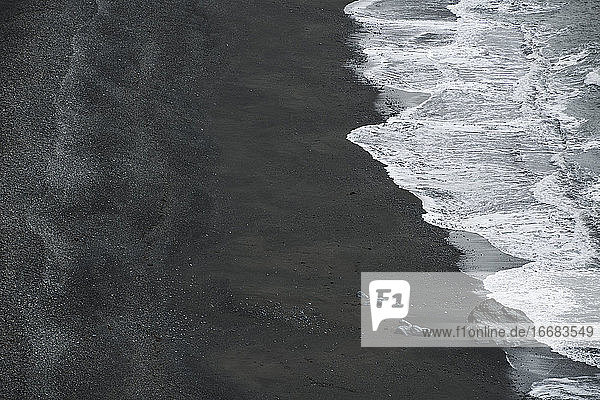 Wellen am schwarzen Sandstrand Reynisfjara in Island
