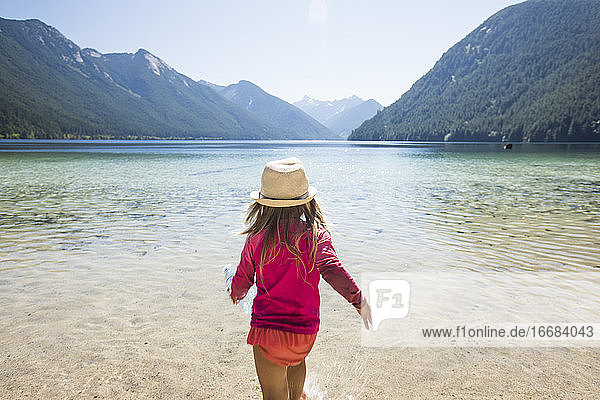 Rear view of toddler girl walking into Chilliwack Lake  B.C. Canada.