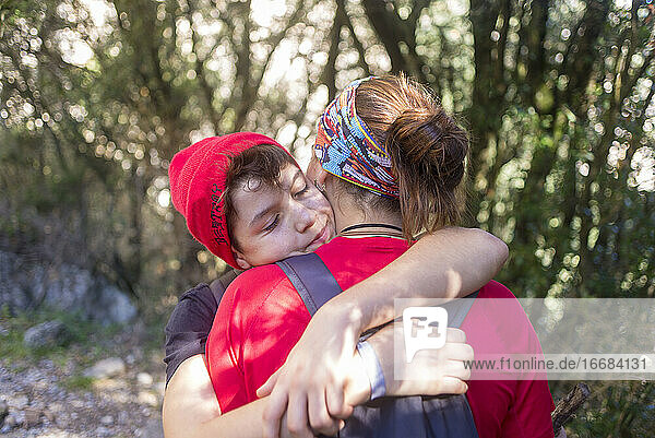 Zwei junge Menschen umarmen sich im Freien in einem Wald