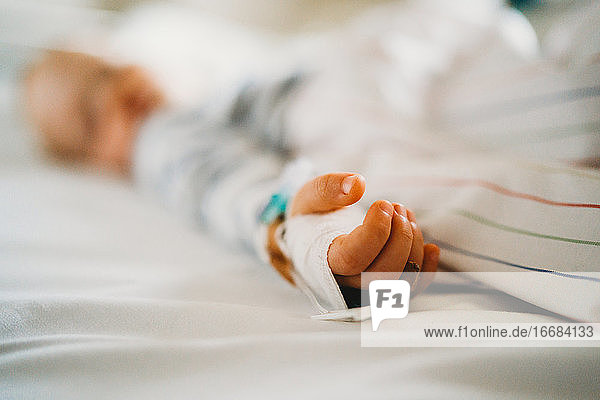 Baby Kind Hand mit IV krank im Krankenhaus mit einem Virus Coronavirus