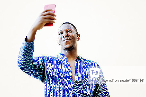 junger afrikanischer Mann macht ein Selfie mit seinem Smartphone