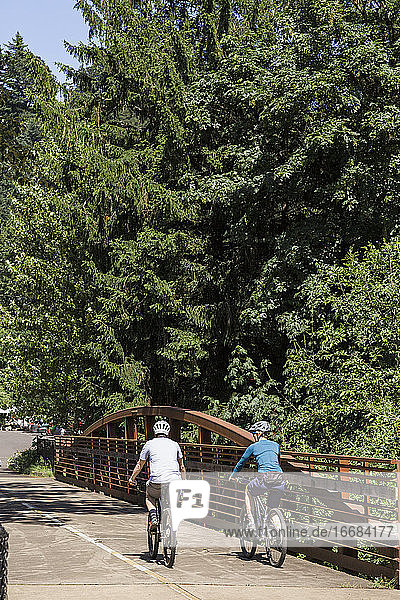 A young couple ride bikes on a trail near Troutdale  Oregon.