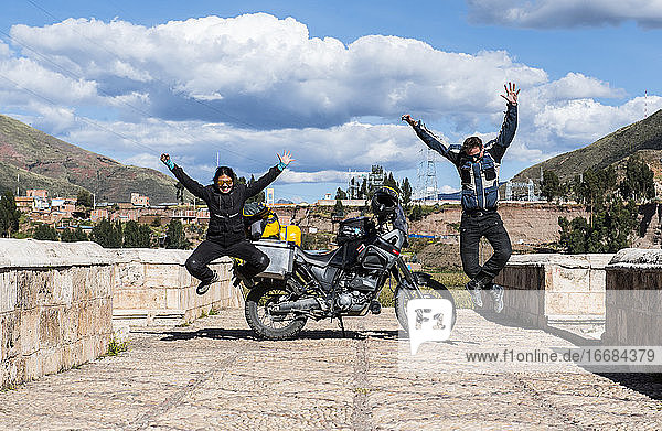 Feiernde Motorradfahrer auf der Brücke über den Urubamba-Fluss  Peru