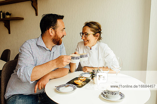 Glückliches Paar  das sich anschaut  lächelt und einen Cappuccino trinkt