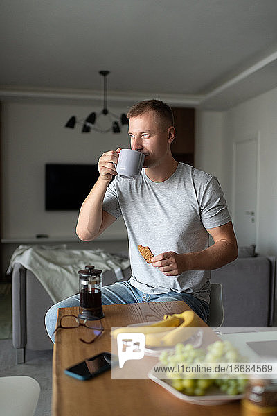 Mann beim Frühstück zu Hause