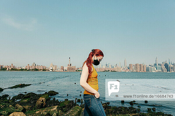 Junge Frau mit Gesichtsmaske an der Brookyln Waterfront.