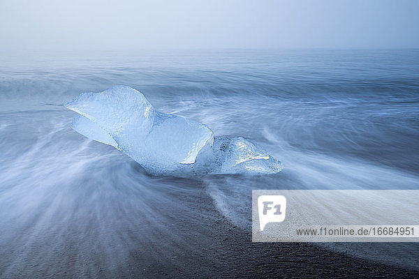 Eisbrocken am Meeresufer am Diamantstrand in der Nähe der Gletscherlagune Jokulsarlon bei nebligem Wetter  Island
