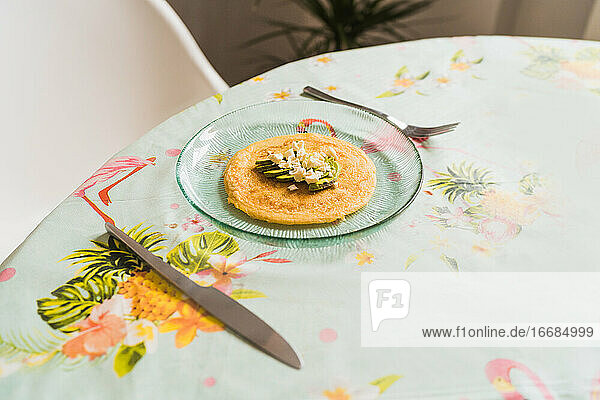Ein Teller mit Pfannkuchen mit Käse und Avocado steht auf dem Tisch
