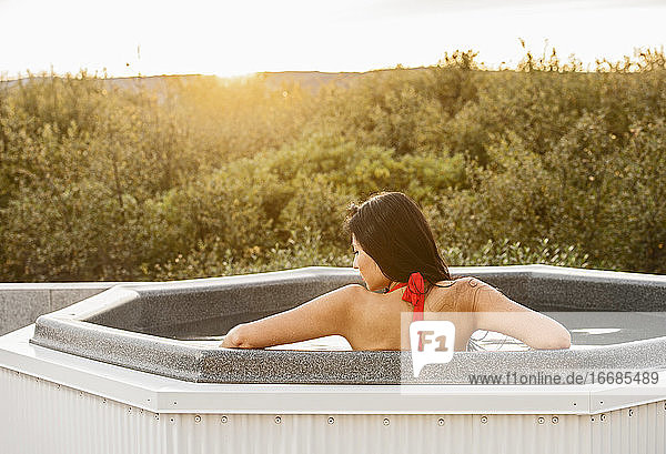 Schöne Frau entspannt im Whirlpool in einer Ferienvilla in Island