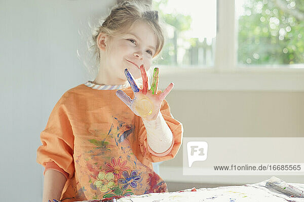 Young girl smiling with paint on her hand