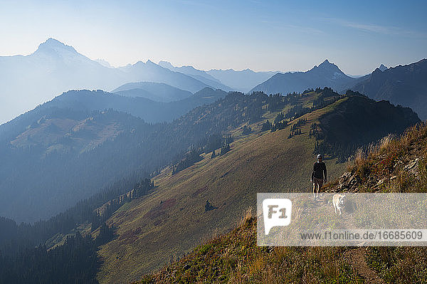 Wildfire Smoke Mountain Layers mit männlichen Wanderer und Hund