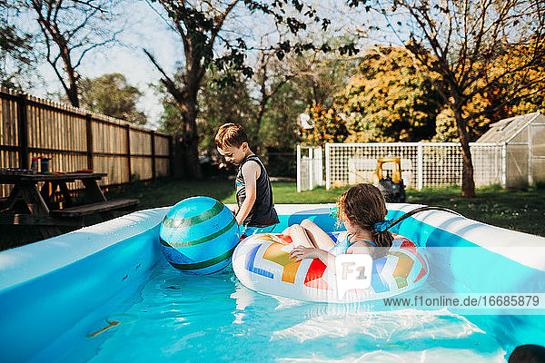Zwei Kinder im Vorschulalter schwimmen im Pool im Hinterhof