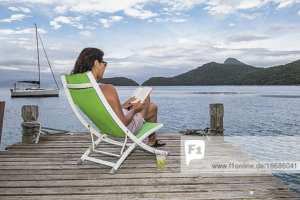 Frau entspannt sich am Pier auf der tropischen Insel Ilha Grande