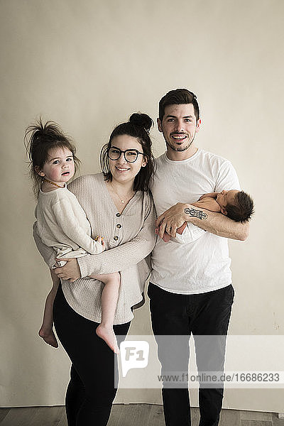 Smiling Hipster Millennial Family With Toddler and Newborn
