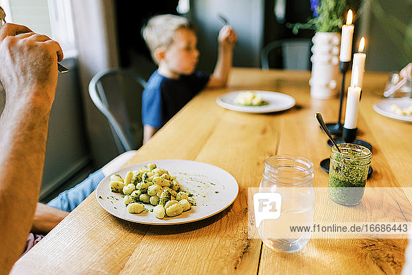 Eine junge Familie genießt ein gemeinsames Abendessen mit ihrem selbst angebauten Pesto