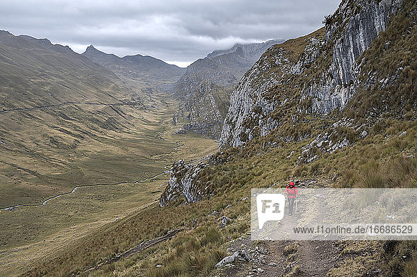 Eine Person mit roter Jacke beim Wandern auf dem Huayhuash-Rundweg
