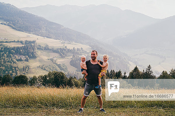 Father and children smiling at the camera in the alps during holidays