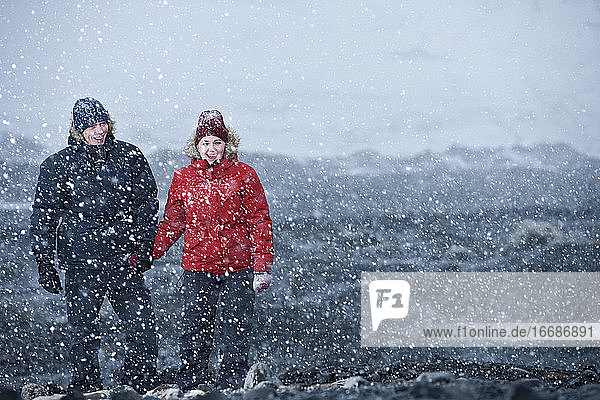 couple walking through snowstorm in Iceland