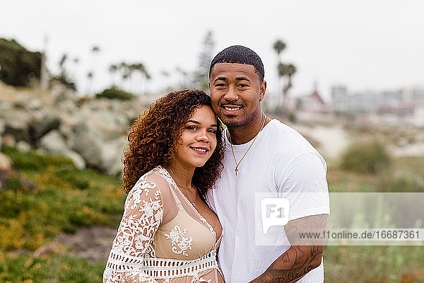 Mixed Race Couple Smiling for Camera on Beach