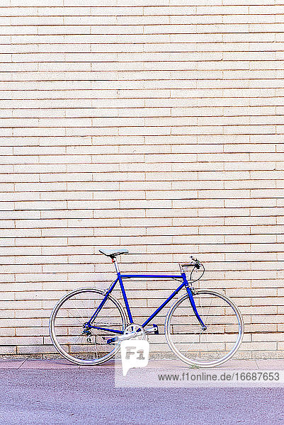 Vintage blauen Fahrrad lehnt an einer Stadt Backsteinmauer