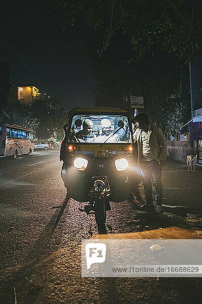 Tuk Tuk  auch als Auto bekannt  nimmt einen jungen indischen Mann nachts in den Straßen von Agra mit.