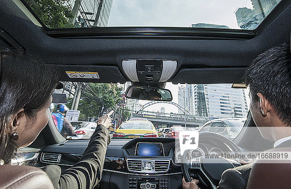 business couple driving at rush hour through Bangkok