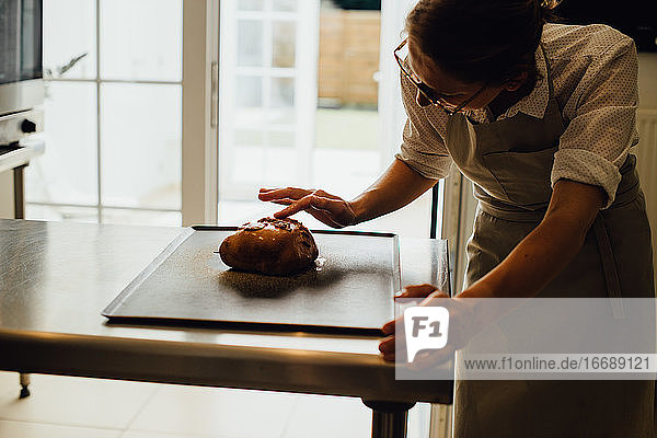 Bäckerin in Uniform dekoriert Brot bei der Arbeit in der Bäckerei