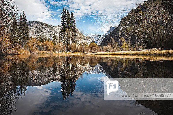 Mountains and trees reflecting in Merced River