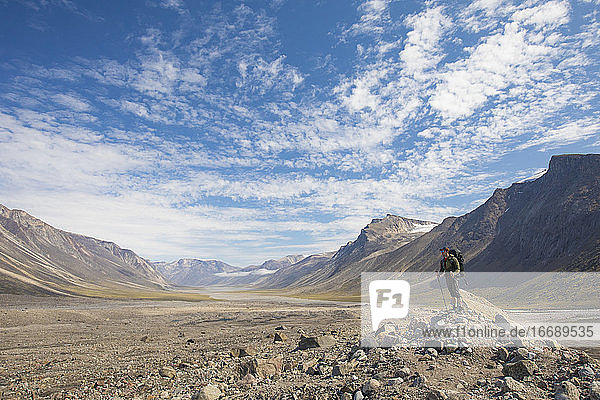 Rucksacktourist betrachtet die Landschaft von der Spitze einer Gletschermoräne aus.