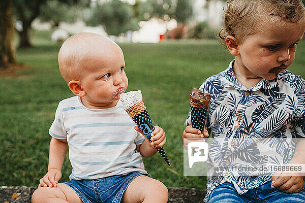 Junges weißes Kleinkind und Baby essen Eiscreme im Sommer
