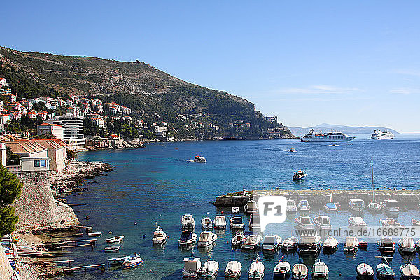 Belebter Hafen mit Kreuzfahrtschiffen in der Ferne  die in Dubrovnik einlaufen