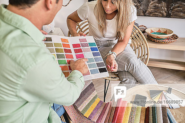 Stoffverkäufer zeigt einer Dame die Farbkarte