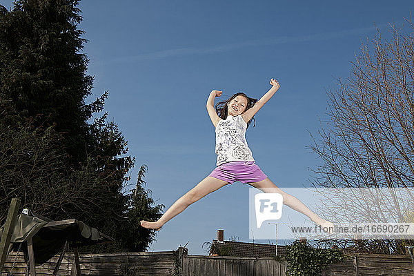 junges Mädchen springt auf einem Trampolin in Woking - England