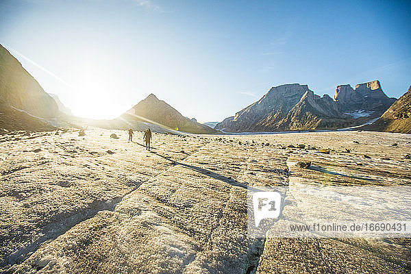 Rucksacktouristen überqueren den Gletscher bei Sonnenuntergang.