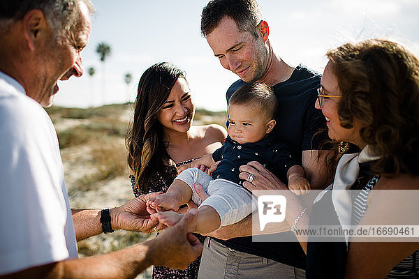 Family Smiles as Dad Holds Baby on Beach