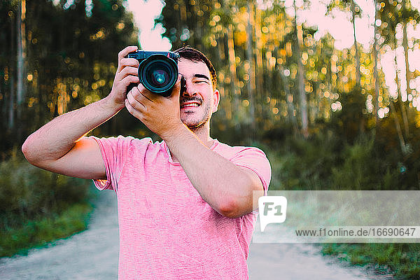 Portrait of young man taking photo with camera