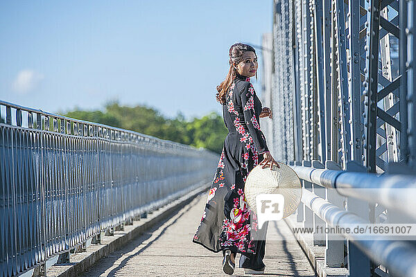 schöne Frau beim Spaziergang über die Truong-Tien-Brücke in Hue / Vietnam
