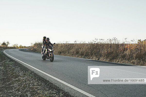 couple riding a motorcycle on the road