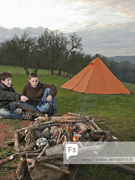 two boys sitting at campfire in South Wales