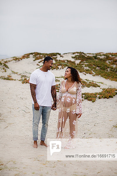 Mixed Race Couple on Beach Posing for Maternity Photos