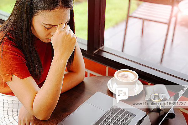 Frau müde nach langer Arbeit am Laptop