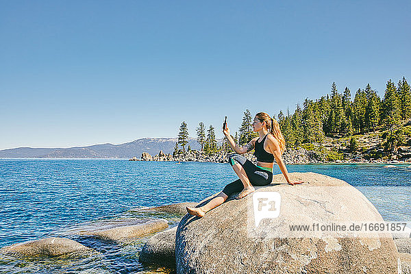 Junge Frau beim Fotografieren des Lake Tahoe.
