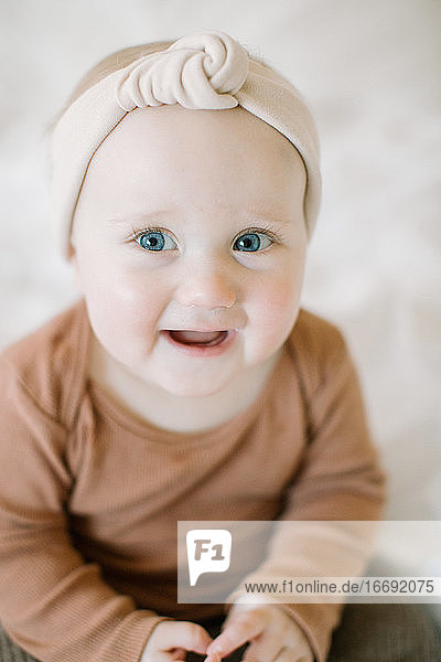Nahaufnahme von Baby-Mädchen lächelnd in die Kamera mit großen blauen Augen