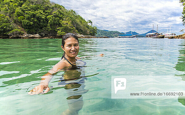 Frau beim Schwimmen in der grünen Lagune auf der tropischen Insel Ilha Grande